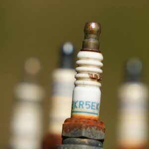 Close-up of spark plug with rusty threads and blurred background